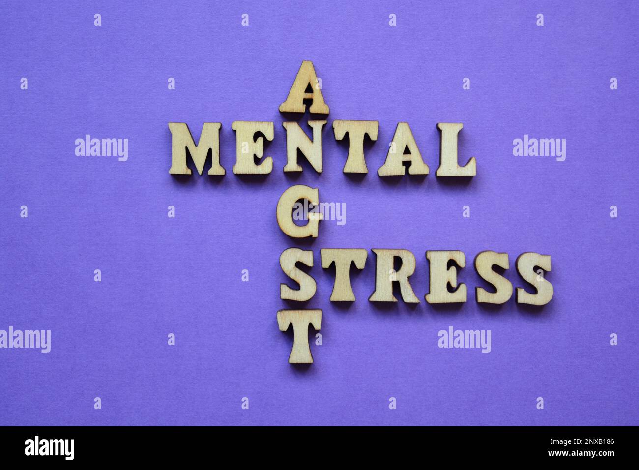 Geistig, Stress, Angst, Wörter in hölzernen Buchstaben in Kreuzworträtselform isoliert auf lila Hintergrund Stockfoto