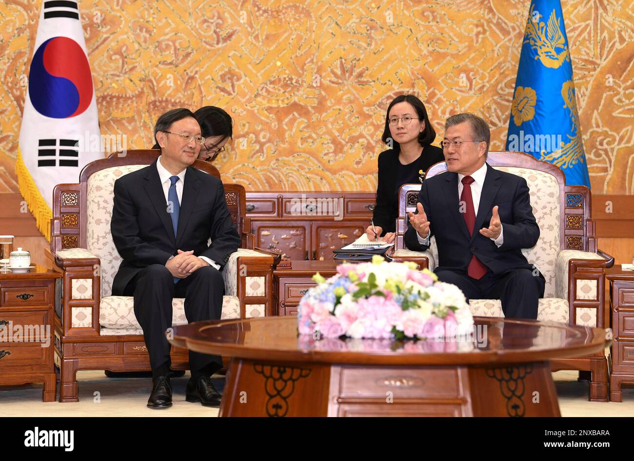 South Korean President Moon Jae-in, right, shakes hands with Chinese