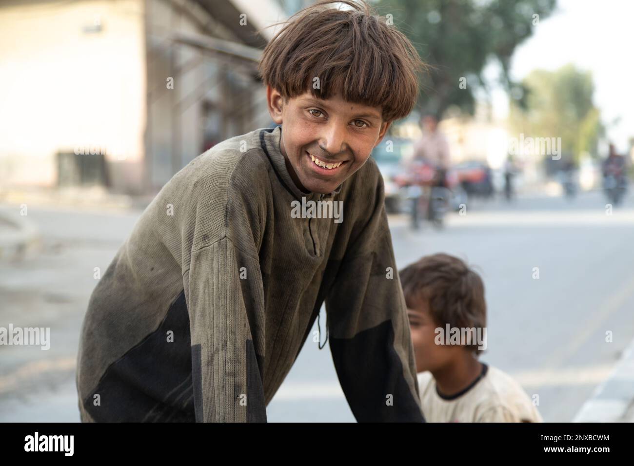 Syrische Kinderarbeiterin mit schmutzigen Kleidern und Gesicht im selektiven Fokus. Das syrische Flüchtlingskind lächelt trotz allem. Jarabulus, Aleppo, Syrien. Stockfoto