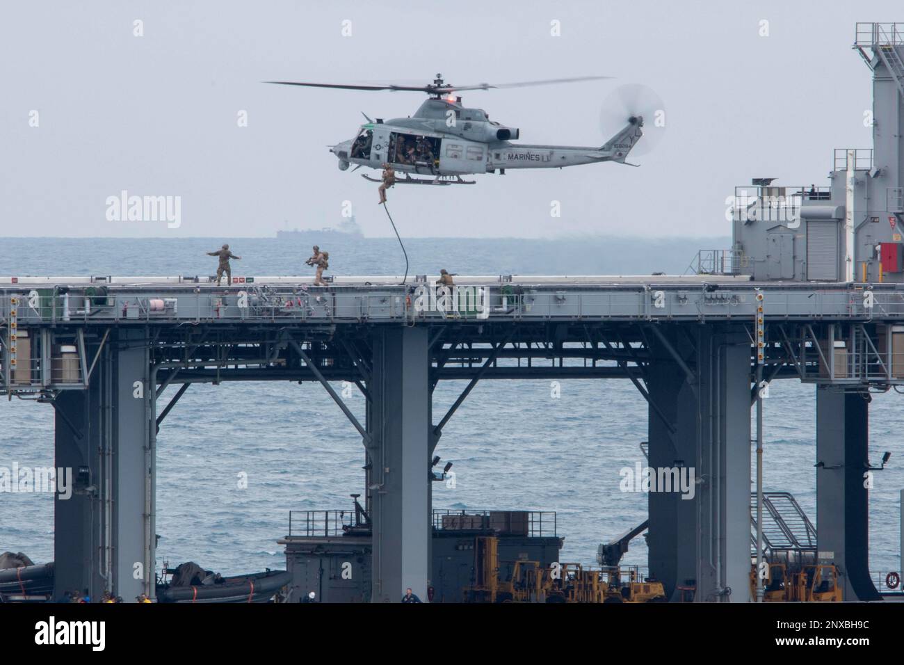 NATUNA SEA (7. Januar 2023) – Marines, die einem Marine-RAID-Force-Zug (MRF) zugeteilt wurden, begannen an Bord der Amphibien-Transportanlage USS Anchorage (LPD 23), ein schnelles Seil hinunter an einem UH-1Y-Gift, das dem variablen Tiltrotor-Geschwader (VMM) 362 zugeteilt wurde, um an Bord von Lewis B. Puller-Klasse-Expeditionsbasis USS Miguel Keith (ESB 5) zu gehen. Für eine VBSS-Trainingsübung (Visit, Board, Search, and seizure), Januar 7. Die Fähigkeit, nahtlos und gleichzeitig auf See, an Land und in der Luft zu arbeiten, stellt den einzigartigen Wert der amphibischen Fähigkeiten dar, die das ARG/MEU-Team bietet. Die Makin Island Amphibious Ready Group, Comp Stockfoto