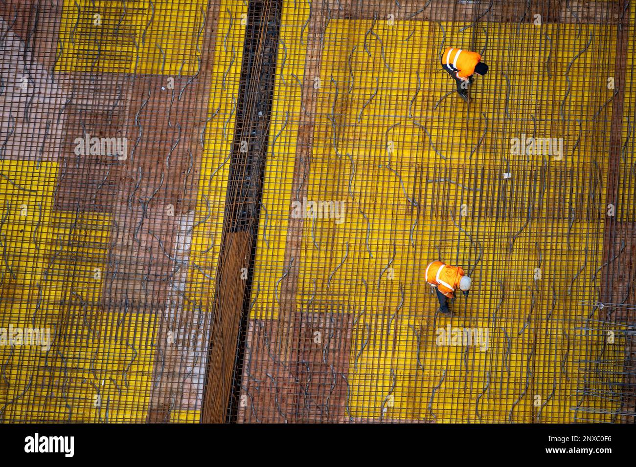 Draufsicht von Arbeitern, die eine Betongrundplatte auf einer Baustelle vorbereiten. Stockfoto