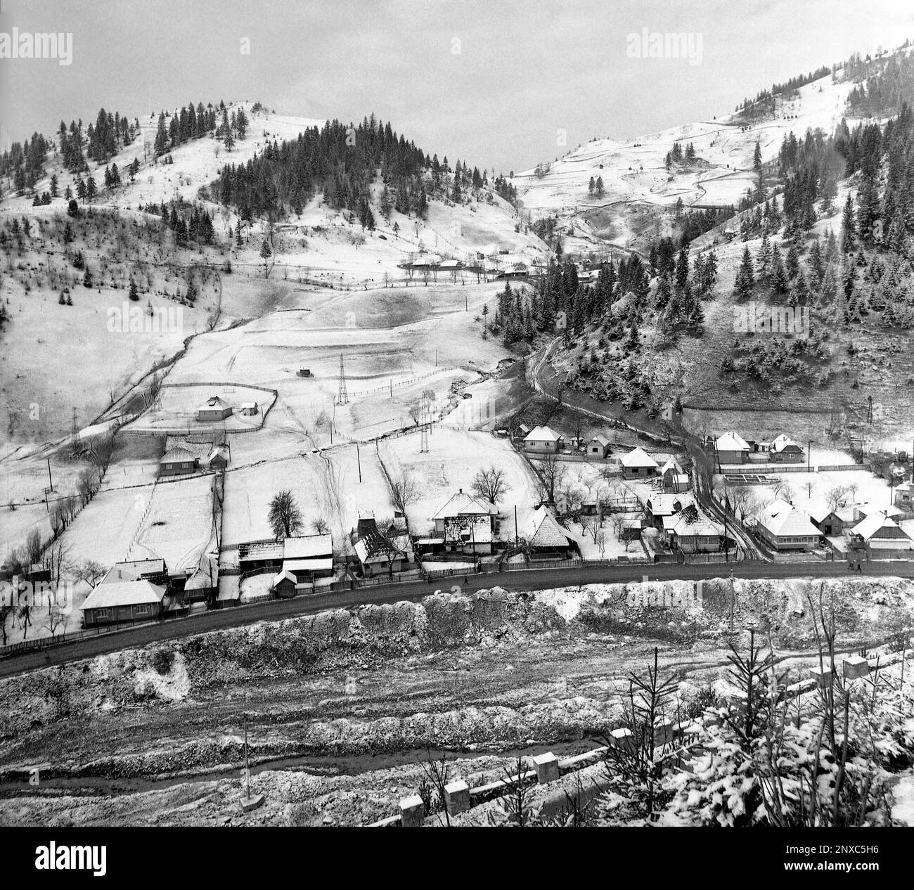 Arges County, Sozialistische Republik Rumänien, ca. 1975. Winterlandschaft in einer Bergregion mit Häusern am Fluss. Stockfoto