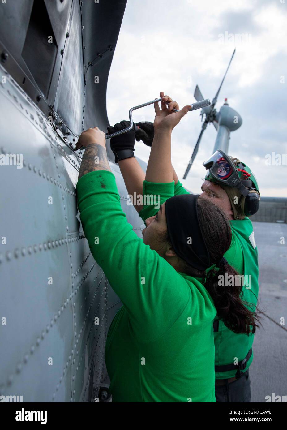 230202-N-HG846-1040 SINGAPORE STRAIT (2. Februar 2023) – Aviation Machinist Mate 3. Class Sylvia Slenandore, Front, aus Austin, Texas, und Aviation Structural Mechanic 2. Class Mason Bou, aus Henderson, North Carolina, Entfernen eines Panels aus einem MH-60s Seahawk, der den ‚Blackjacks‘ der Helicopter Sea Combat Squadron (HSC) 21 während der routinemäßigen Wartung auf dem Cockpit an Bord des Küstenschiffes USS Charleston (LCS 18) in der Straße von Singapur zugewiesen ist, Februar 2. Charleston, Teil der Destroyer-Geschwader 7, ist in Rotation im US-7.-Flottengebiet operiert Stockfoto