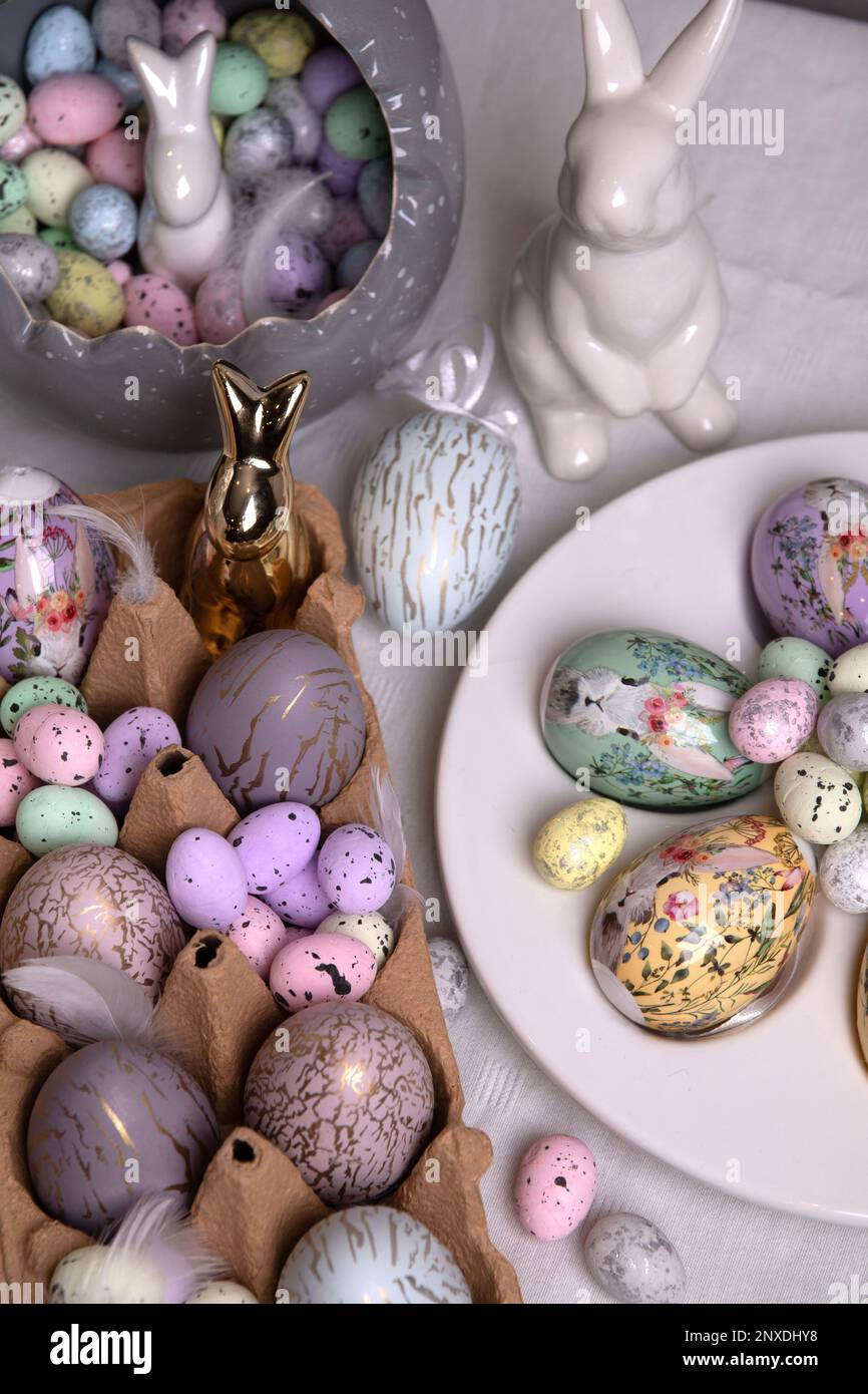 Fotodekorative Eier verschiedener Formen und Farben und ein Kaninchen auf dem Tisch Stockfoto