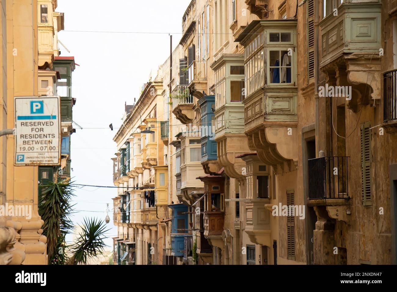 Valletta, Malta - 12. November 2022: Verwitterte Kalksteinfassaden mit traditionellen Holzbalkonen in Maltas Hauptstadt Stockfoto
