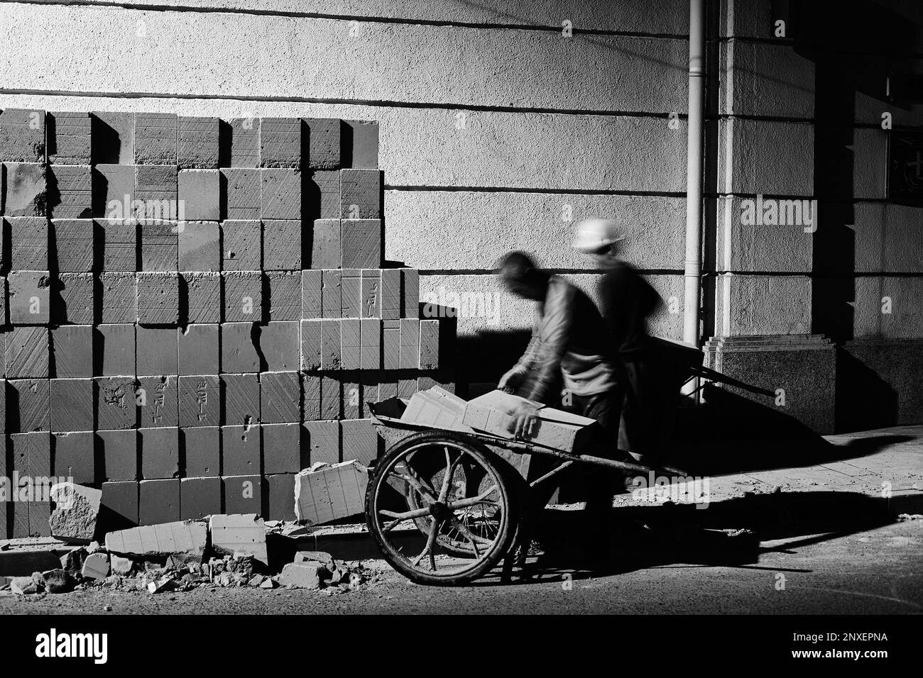 Zwei Bauarbeiter arbeiten nachts auf einer Straße in Shanghai Stockfoto