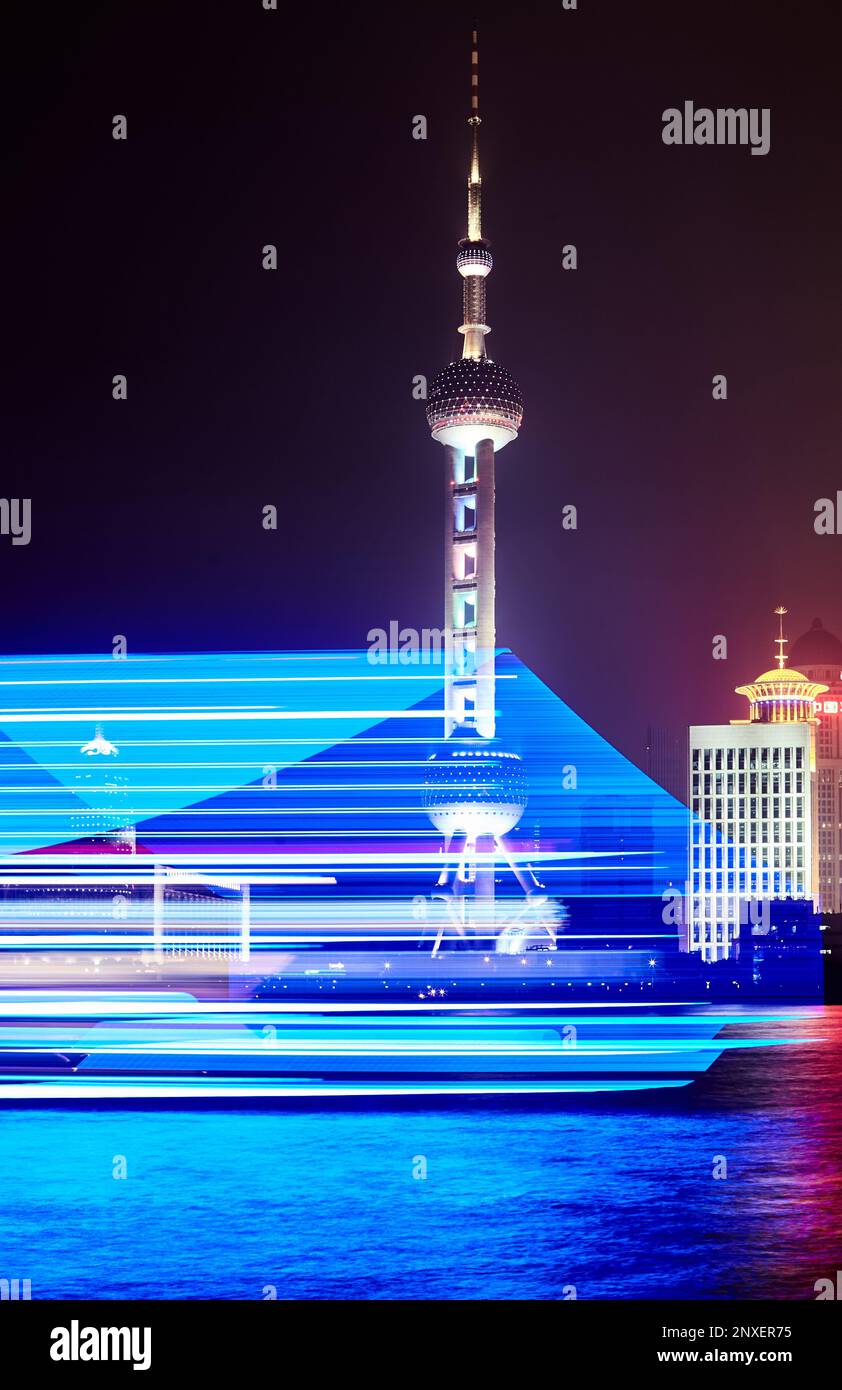 Nachtaufnahme eines blau beleuchteten Bootes auf dem huangpu, vorbei am orientalischen Perlenturm Stockfoto