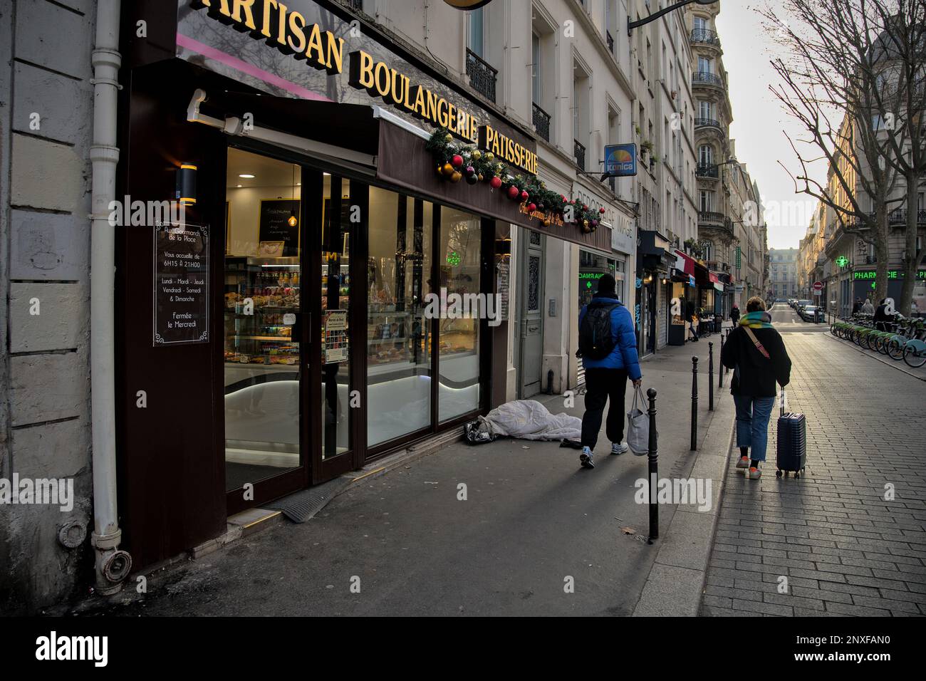 Obdachlose, die morgens vor einer Bäckerei schlafen. Paris, Frankreich Stockfoto