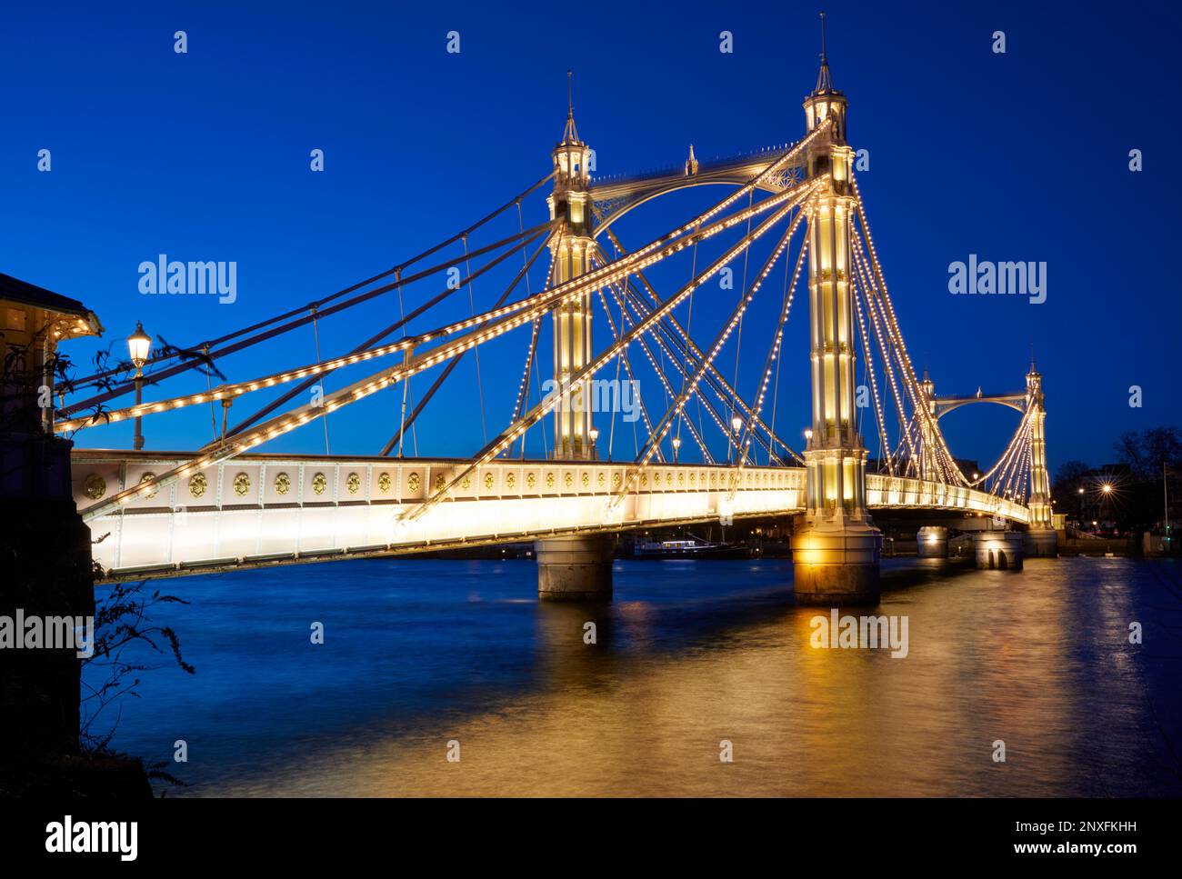 Die beleuchtete Albert Bridge in der Abenddämmerung, London, England, GB Stockfoto