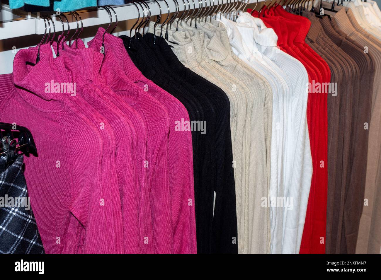 Modekleidung auf Kleiderbügeln bei der Show. Modische, farbenfrohe Kleidung im Kleiderschrank. Das Frühjahrsputzkonzept. Herbstgarderobe. Stockfoto