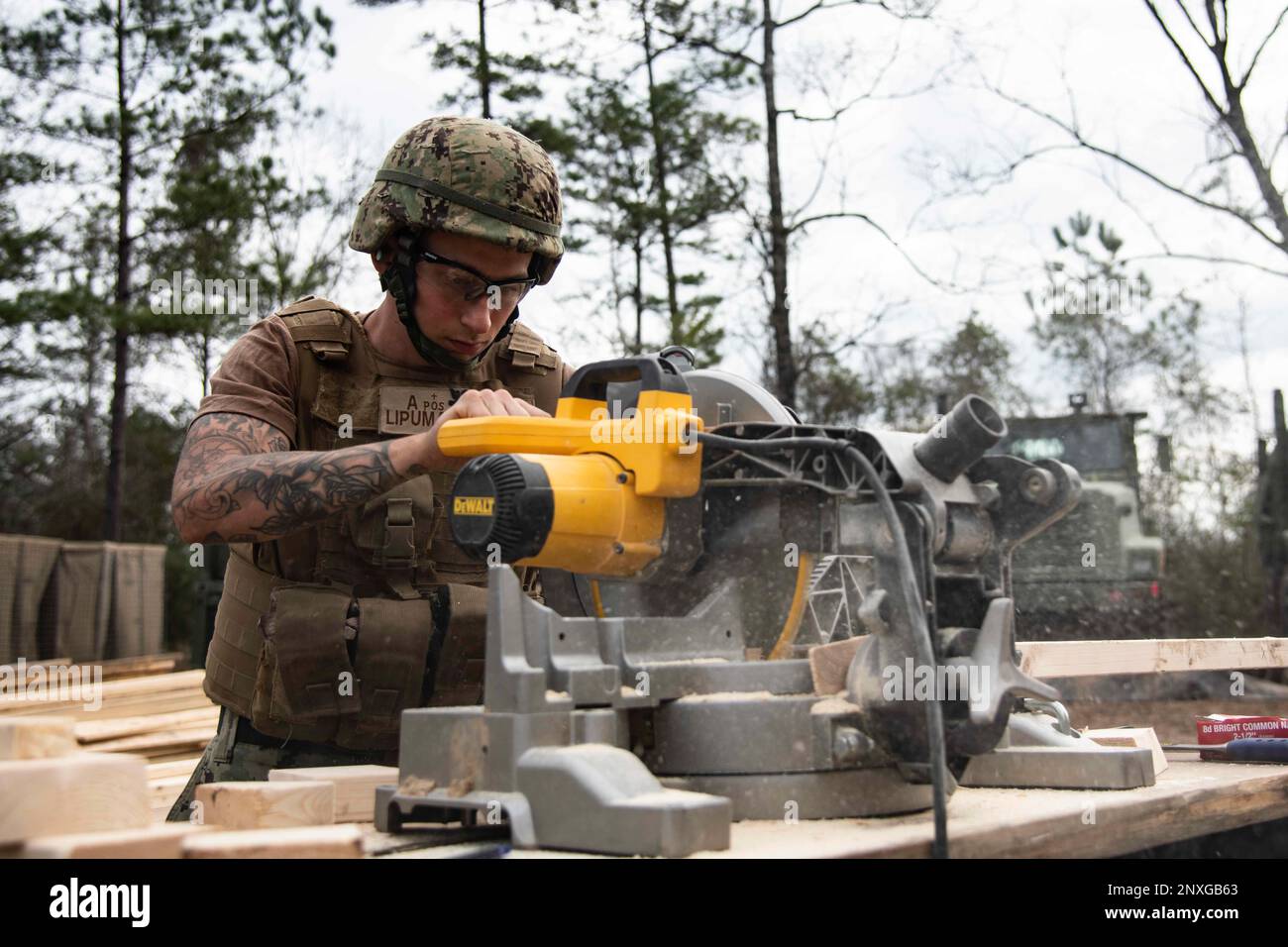 220207-N-PI330-1031 Camp Shelby, Mississippi (7. Februar 2023) Baumeister 2. Klasse Angelo LiPuma, dem Naval Mobile Construction Battalion 133 (NMCB 133) zugeteilt, schneidet Stollen für eine SEEHÜTTE in Camp Shelby, Mississippi, 7. Februar 2023. NMCB 133 führt im Camp Shelby, Mississippi, eine Feldübung durch, die im Rahmen des Navy Expeditionary Combat Command durchgeführt wird und die Fortgeschrittensphase des Einsatzbereitschaftstrainings (FRTP) durchführt. Stockfoto