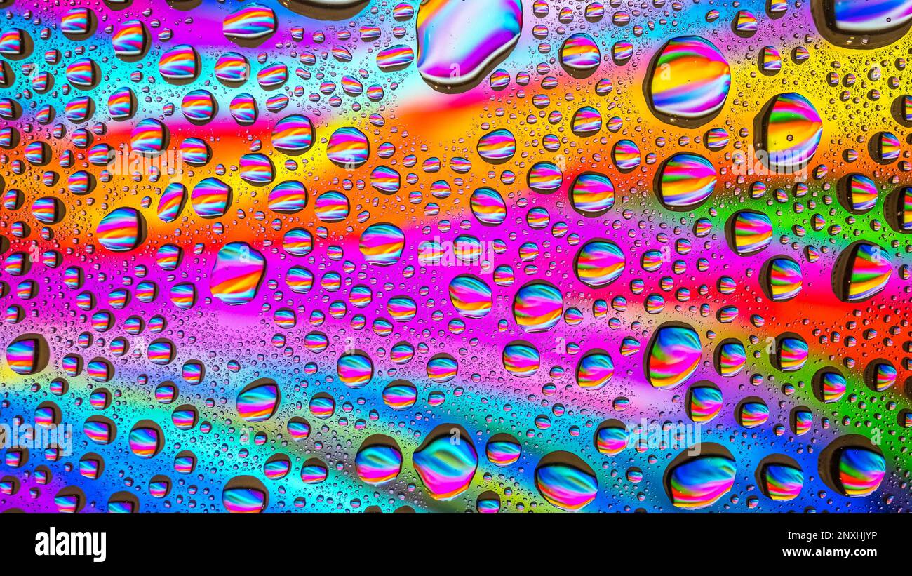Das Wasser tropft über einem bunten abstrakten Hintergrund Stockfoto