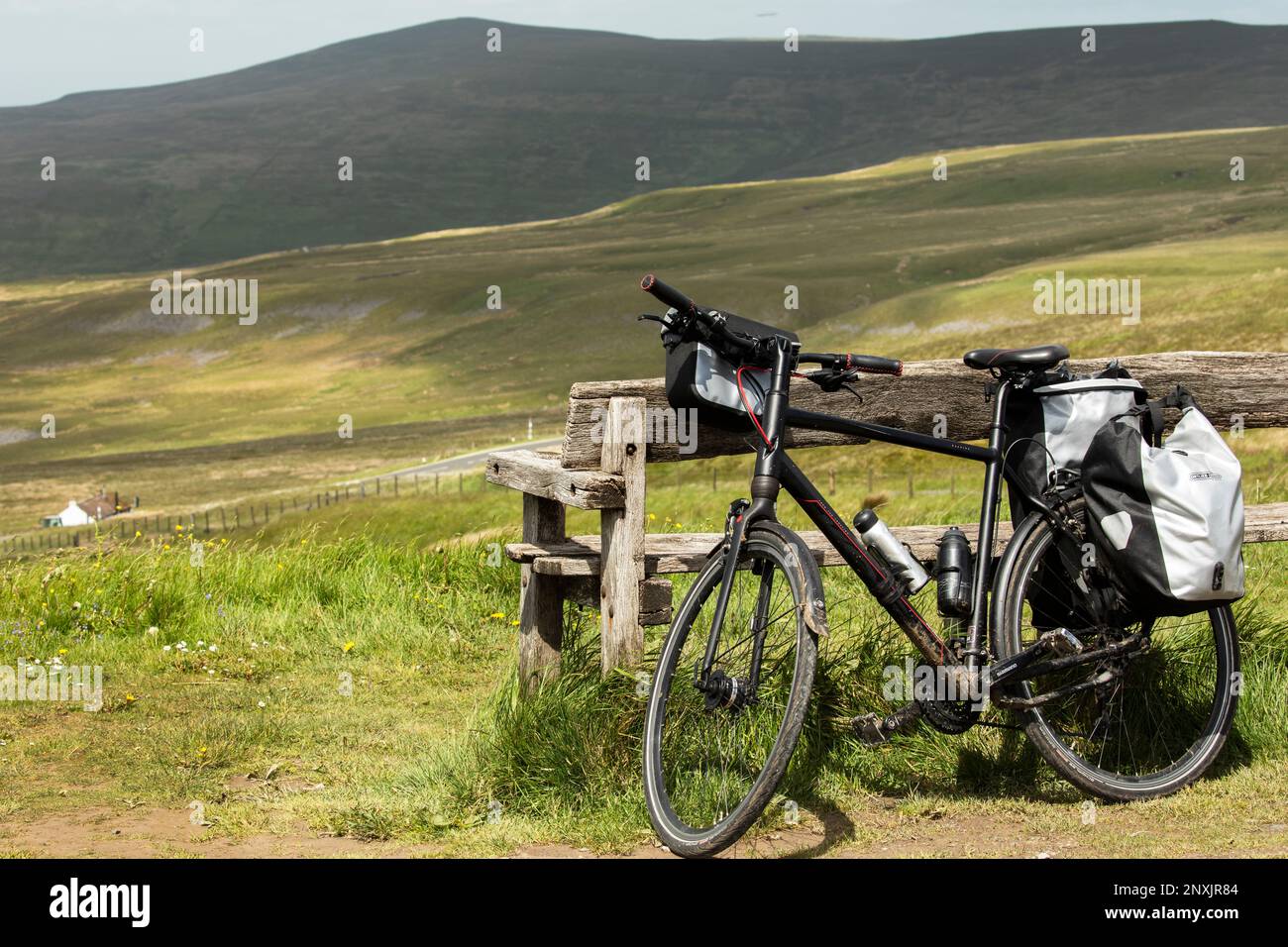 Am Hartside Pass Summit in der Nähe von Alston, North Pennines, Cumbria ruht ein Fahrrad auf einer Bank Stockfoto