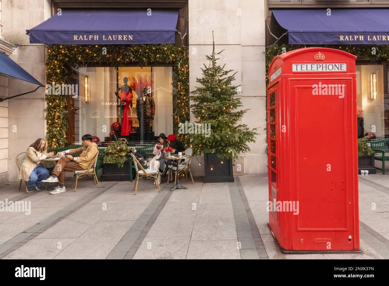England, London, Piccadilly, New Bond Street, Außenansicht des Ralph Lauren Store mit Weihnachtsdekorationen und traditioneller roter Telefonzelle Stockfoto