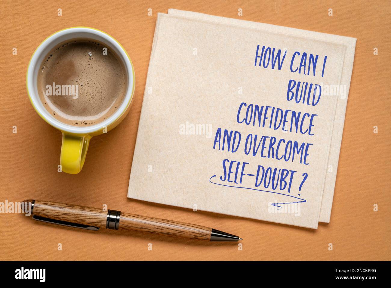 Wie kann ich Selbstvertrauen aufbauen und Selbstzweifel überwinden? Inspirierende Frage auf einer Serviette. Persönliche Entwicklung und Selbsthilfekonzept. Stockfoto