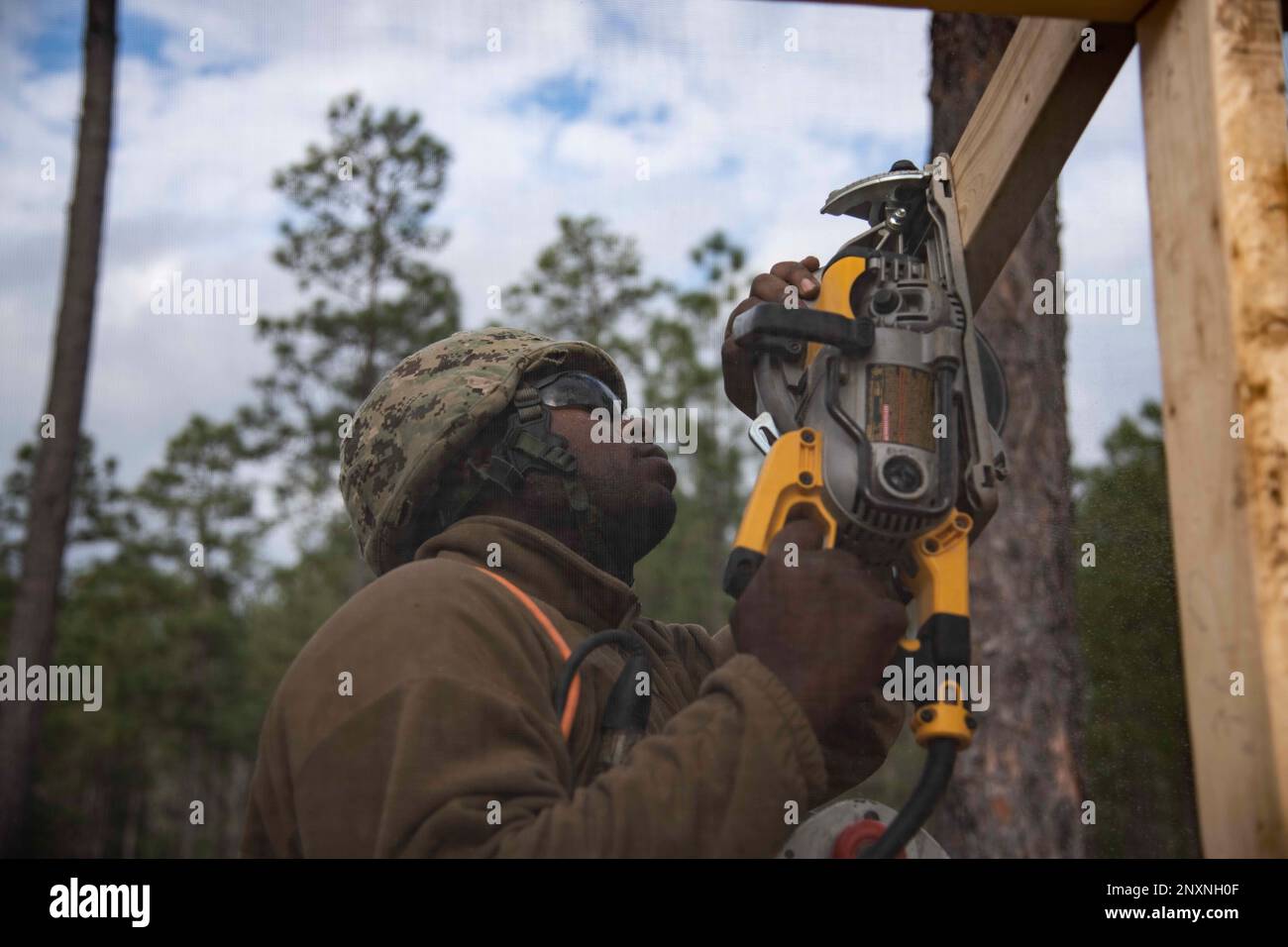 220207-N-PI330-1043 Camp Shelby, Mississippi (7. Februar 2023) Baumeister 2. Klasse Janrite Johnson, dem Naval Mobile Construction Battalion 133 (NMCB 133) zugeteilt, schneidet Sparren für eine SEEHÜTTE in Camp Shelby, Mississippi, 7. Februar 2023. NMCB 133 führt im Camp Shelby, Mississippi, eine Feldübung durch, die im Rahmen des Navy Expeditionary Combat Command durchgeführt wird und die Fortgeschrittensphase des Einsatzbereitschaftstrainings (FRTP) durchführt. Stockfoto