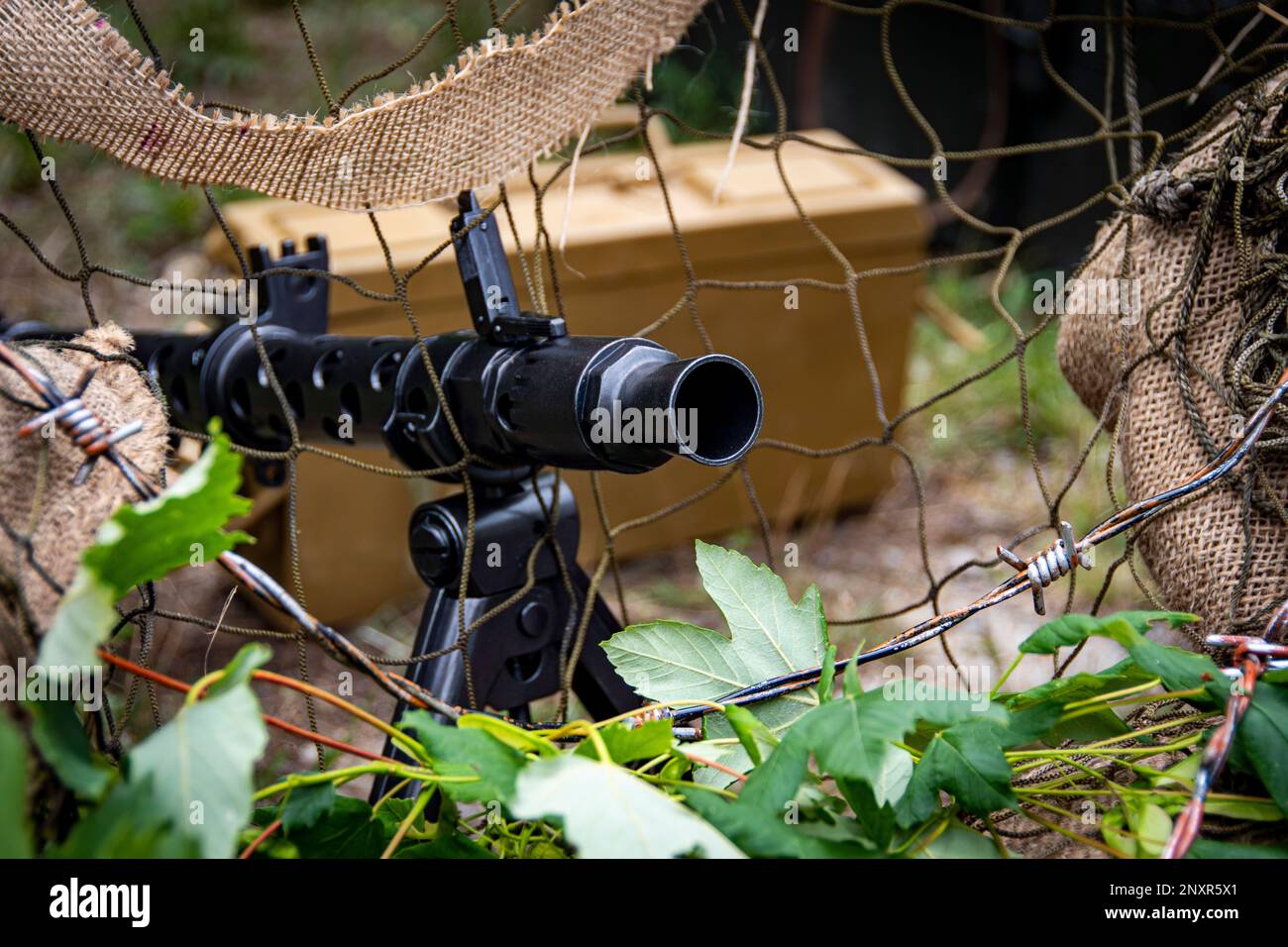deutsches MG 34-Maschinengewehr aus dem Zweiten Weltkrieg hinter Tarnnnetzen Stockfoto
