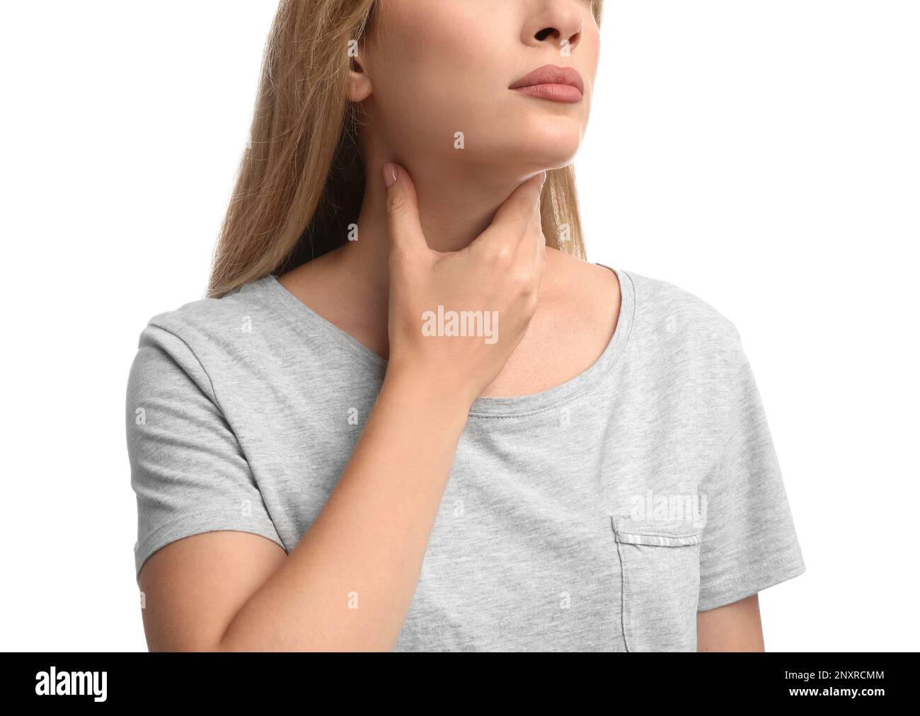 Junge Frau, die Schilddrüsen-Selbstuntersuchung auf weißem Hintergrund macht, Nahaufnahme Stockfoto