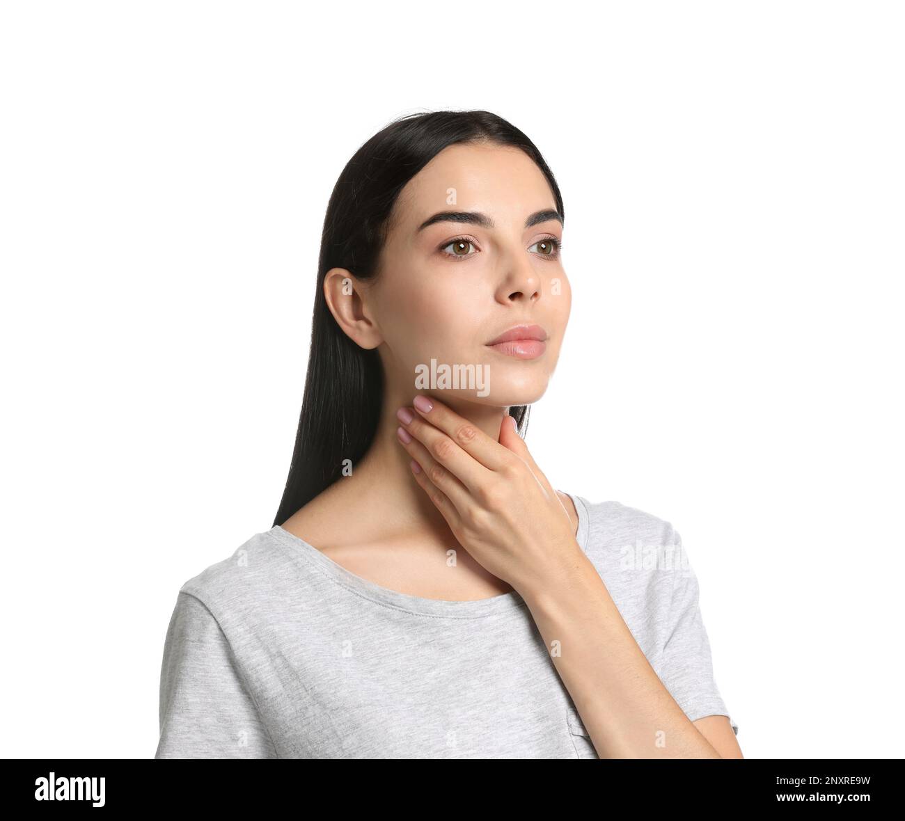 Junge Frau, die Schilddrüsen-Selbstuntersuchung auf weißem Hintergrund macht Stockfoto