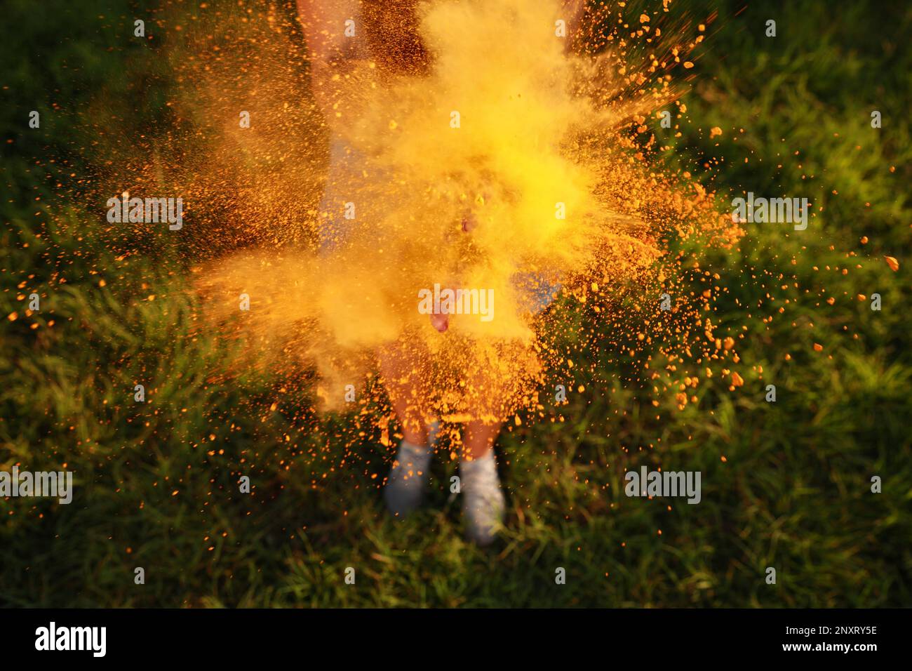 Frau mit orangefarbenem Pulverfarbstoff draußen, Nahaufnahme. Holi-Festival-Feier Stockfoto