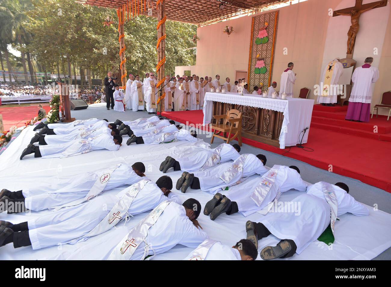 Newly ordained priests lay on down in front of the altar as Pope Francis celebrates mass and