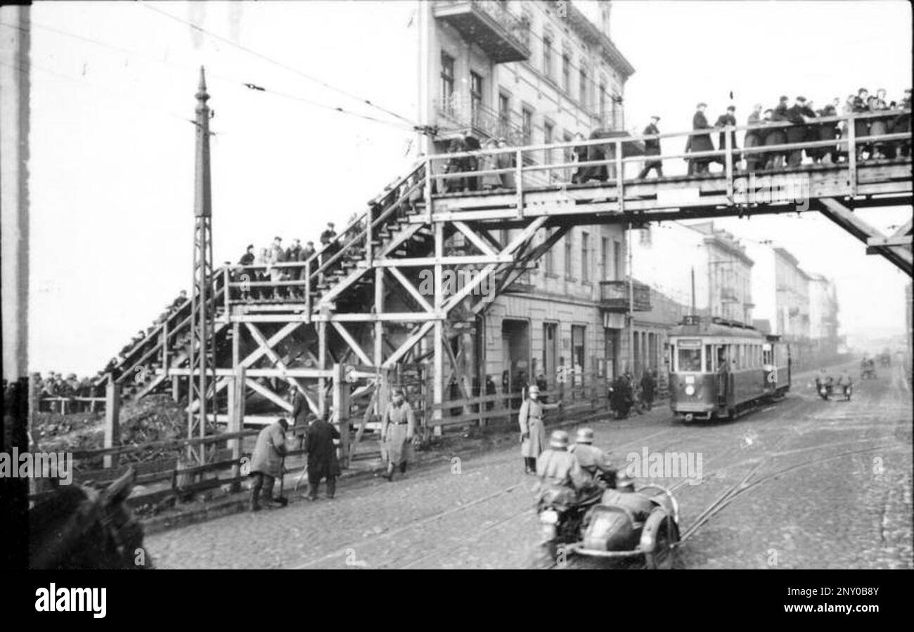 In den frühen Stadien des Jahres WW2 wurden die Juden in den von den nazis besetzten europa zusammengeführt und in überfüllte Ghettos gezwungen. Als die Entscheidung getroffen wurde, sie alle zu töten, wurden sie in Vernichtungszentren deportiert, um sie zu töten. Dieses Bild zeigt eine überfüllte Fußgängerbrücke über die Hohensteiner Straße (jetzt Zgierska Straße). Das Ghetto war versiegelt, und keine Juden durften raus, also musste die Brücke von einem Teil des Ghettos zum anderen überqueren. Bundesarchiv, Bild 101I-133-0703-22/Zermin/CC-BY-SA 3,0 Stockfoto