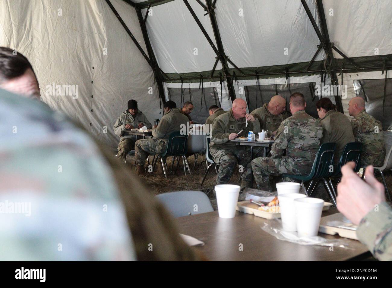 Soldaten der Illinois National Guard genießen am 5. Februar 2023 ein Essen, das von Mitgliedern der Einheit 3, 733. Quartermaster Platoon in Paris, Illinois, zubereitet wird. Anstelle der „normalen“ warmen Mahlzeit bei der Übung erhielten die Soldaten im Rahmen des jährlichen Philip-A.-Connelly-Programmwettbewerbs 55. eine aktualisierte Speisekarte. Stockfoto