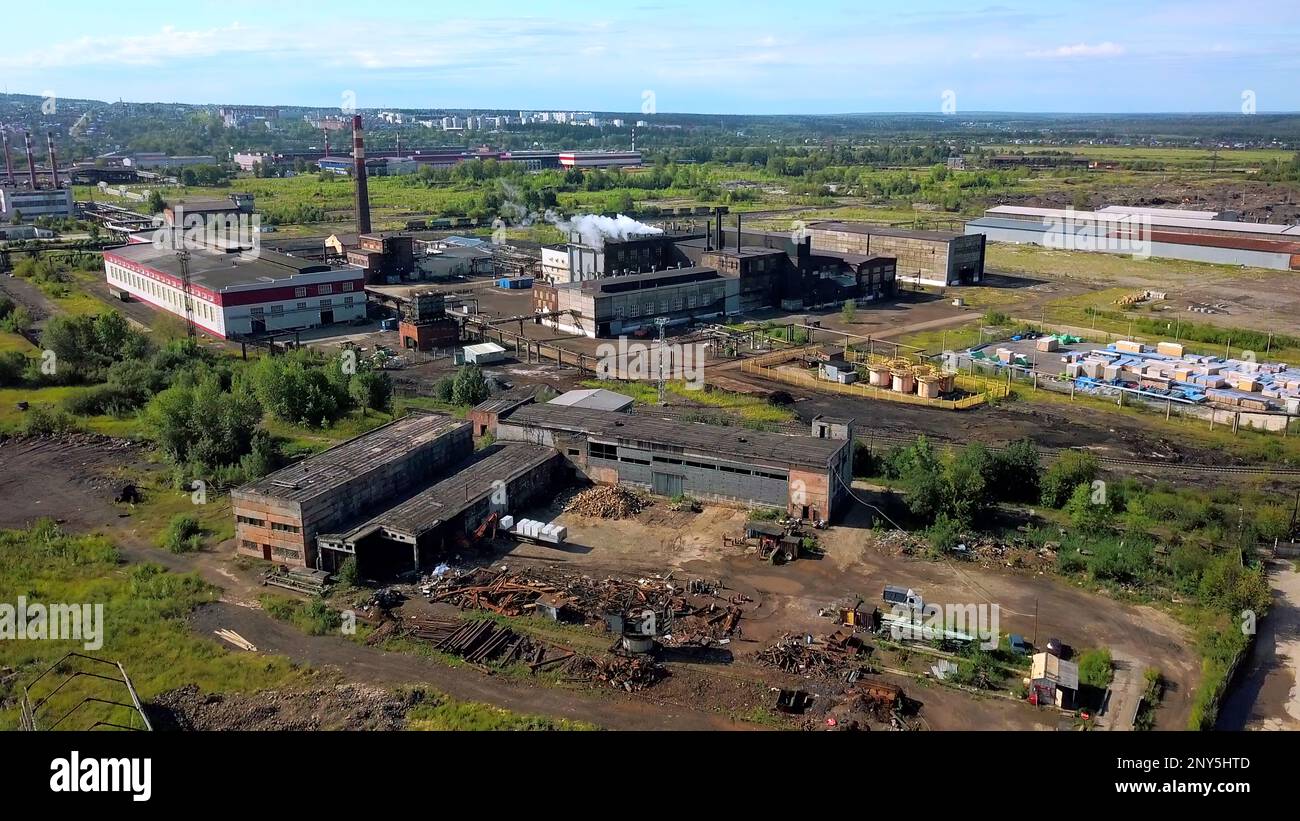Städtische Industrie von der Drohne. Aktion. Ein Blick von der Höhe bis zum Stadtrand mit hohen Schornsteinen, aus denen Rauch austritt. Hochwertige 4K-Aufnahmen Stockfoto