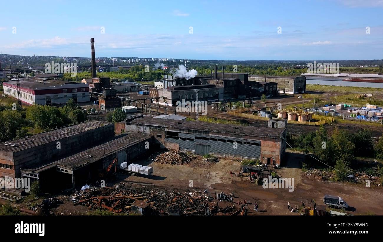 Städtische Industrie von der Drohne. Aktion. Ein Blick von der Höhe bis zum Stadtrand mit hohen Schornsteinen, aus denen Rauch austritt. Hochwertige 4K-Aufnahmen Stockfoto