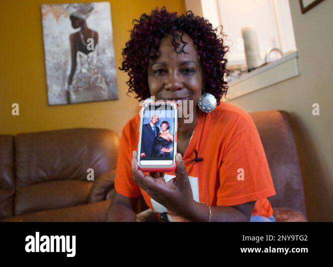 In this September 2017 photo, Lucy Mashia poses for a portrait in Portland, Ore., while showing one of her favorite photos of her son, Leonard James "L.J." Irving, who was killed in a gang related shooting. Portland police have handled 81 gang shootings so far this year - and that's actually a hopeful number for the officers who work on a team dedicated to trying to keep the violence at bay, their boss says. (Olivia Dimmer/The Oregonian via AP) Stockfoto