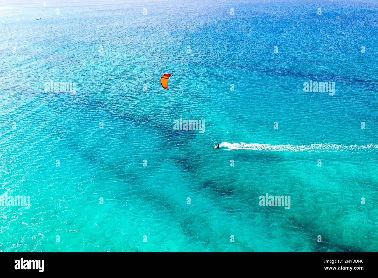 Blick aus der Vogelperspektive auf einen Kitesurfer in einer Bucht mit türkisfarbenem Wasser, an einem beliebten Kitesurfstrand in der Nähe von Santa Maria, Sal Island und Cabo verde Stockfoto