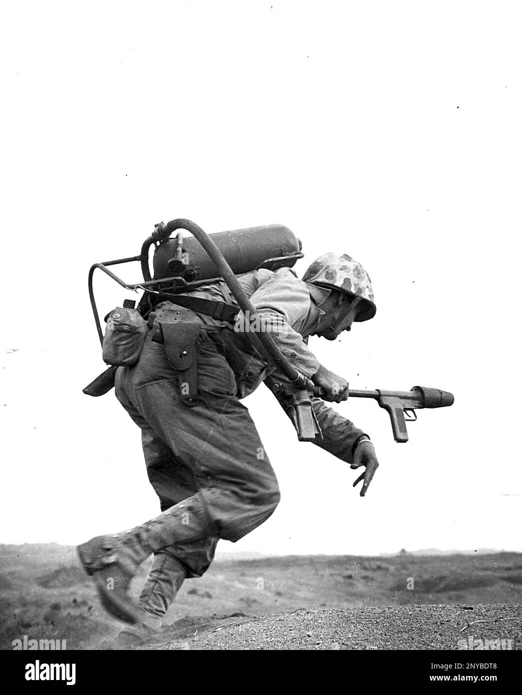 Ein Flammenwerfer-Betreiber der US Marine Corps E Company läuft unter feindlichem Beschuss auf Iwo Jima. Während der Schlacht von Iwo Jima haben Flammenwerfer bewiesen Stockfoto