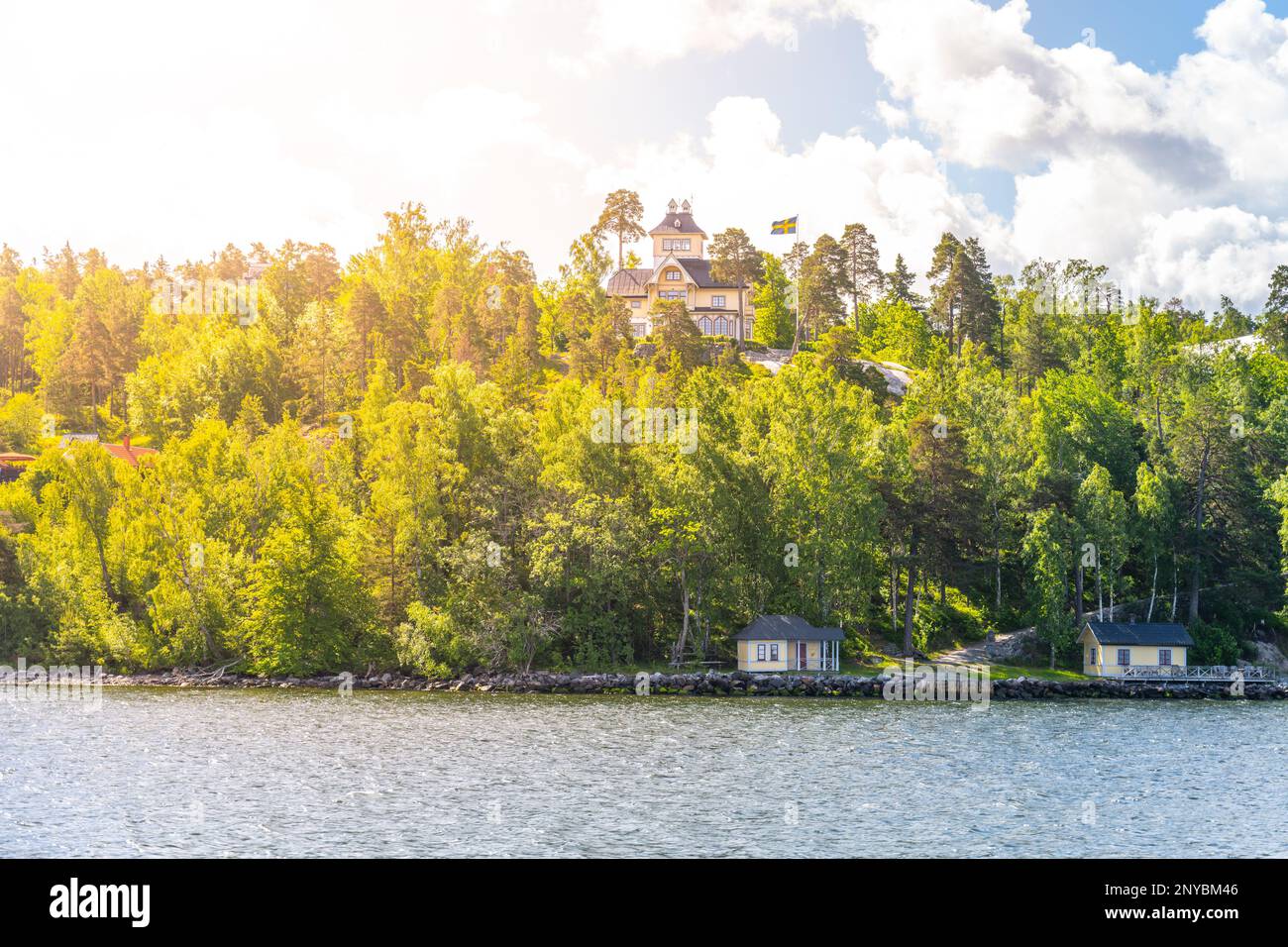 Große Wohnvilla auf einem bewaldeten Hügel mit Blick auf die Küste der schwedischen Inselgruppe. Die Aussicht ist vom Meer an einem klaren Sommertag Stockfoto