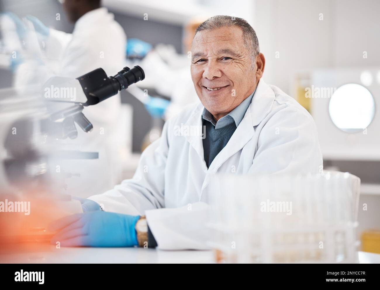 Wissenschaft, Labor und Porträt eines leitenden Wissenschaftlers mit Mikroskop für Forschung, medizinische Studien und Analysen. Gesundheitswesen, Biotechnologie und alter Mann Stockfoto