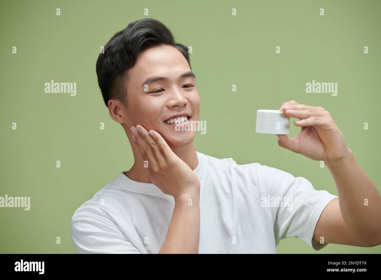 Porträt lächelnder asiatischer Mann im weißen T-Shirt mit Hautpflege. Stockfoto