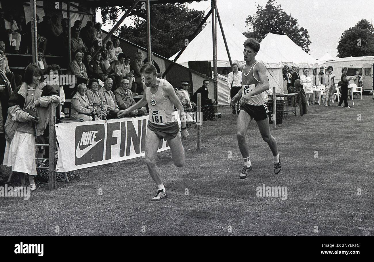 1989, in der Finisher-Linie eines Park-Running-Rennens, sein Gesicht guckt vor Druck, ein älterer männlicher Läufer vor seinem jüngeren Gegner, der eine letzte große Anstrengung unternimmt, um den Sieg zu gewinnen, England. UK. Stockfoto