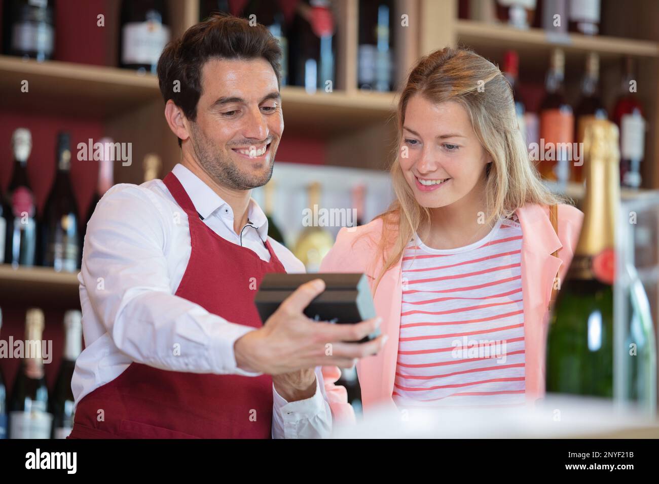 Sommelier mit weiblicher Kundin im Weinkeller Stockfoto
