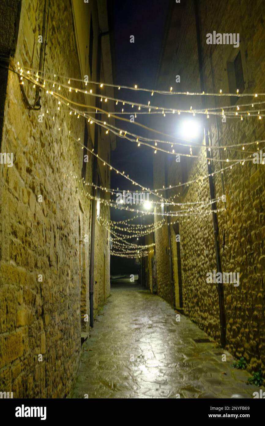Die Lichter der Stadt über den Gebäuden in der Altstadt bei Nacht. Dekorative Stadtbeleuchtung Hintergrund Stockfoto