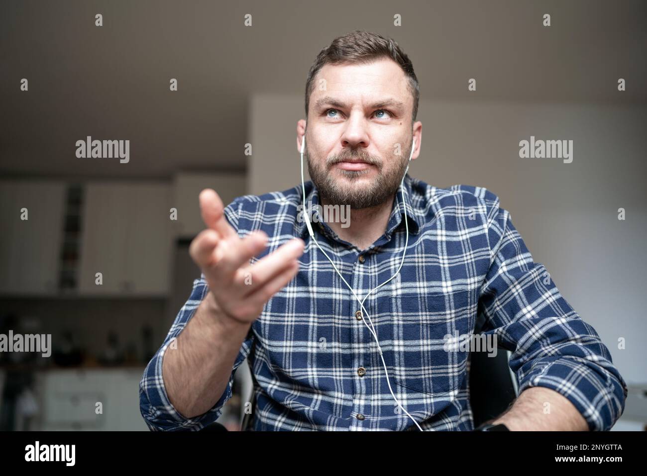 Erwachsener Mann, der von zu Hause aus an einer Webkonferenz teilnimmt. Stockfoto