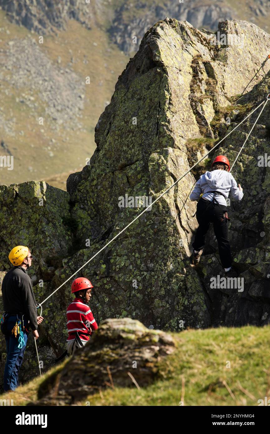 Schulkinder aus der Innenstadt, denen das Klettern in einem alten Steinbruch im Coombs Martindale Ullswater, dem Lake District, Cumbria, beigebracht wird Stockfoto