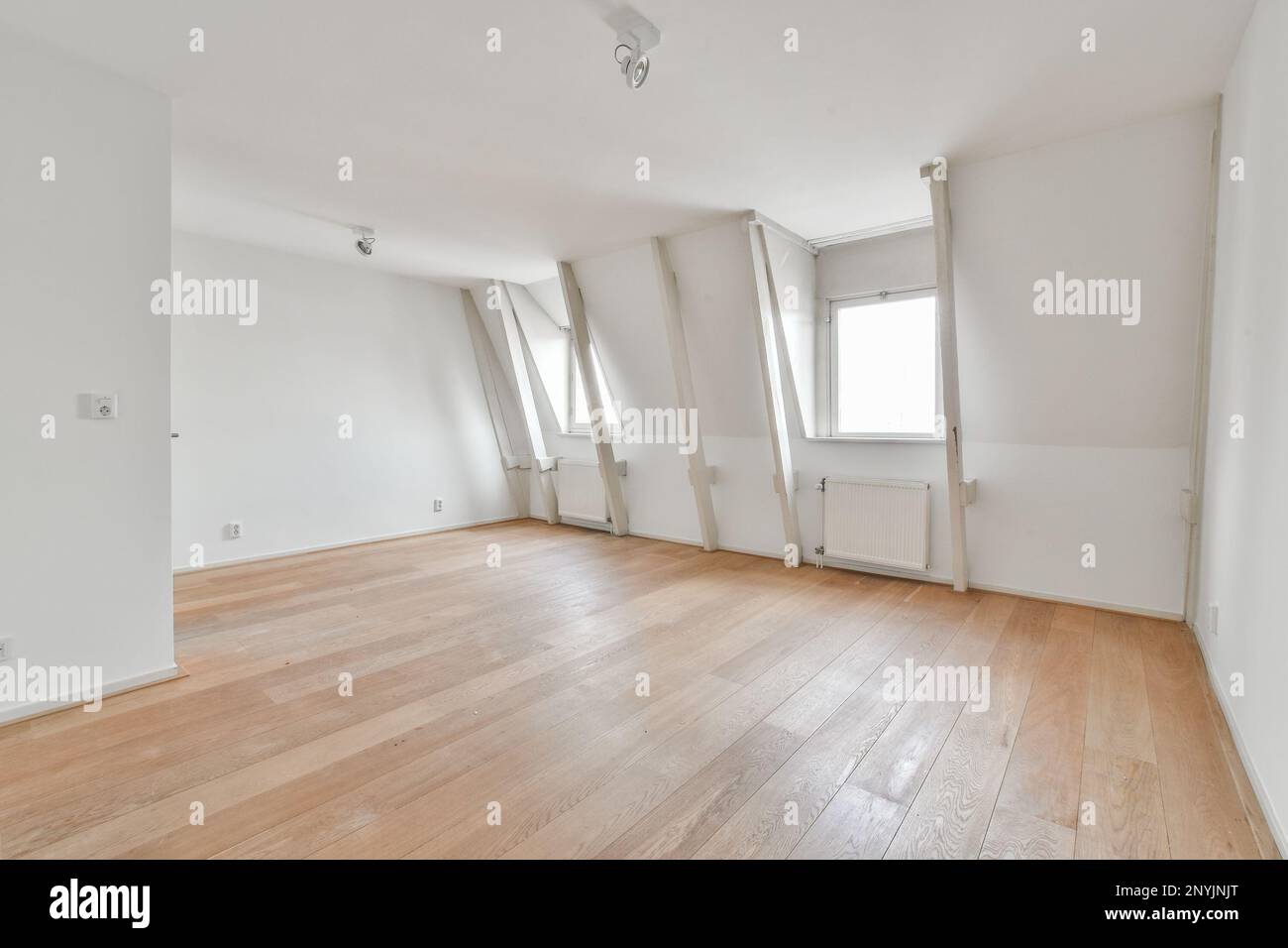 Ein leeres Zimmer mit Holzfußboden und weißen Wänden im Zimmer ist sehr sauber, es ist schwer zu sehen Stockfoto