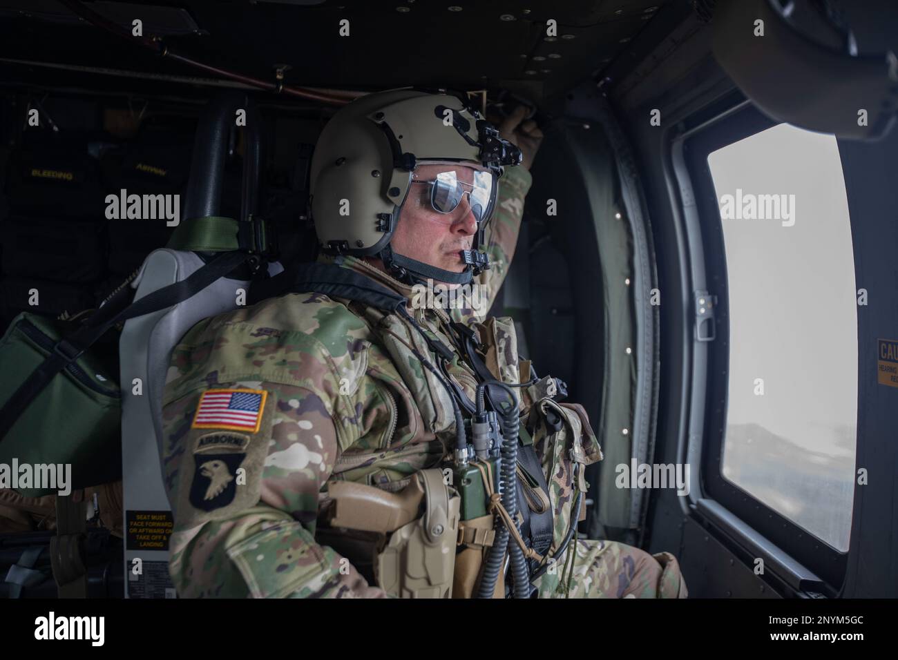 Sgt. 1. Klasse Anthony Bonillas, ein Kosovo Force (KFOR) Regional Command-East (RC-E) Soldat mit der medizinischen Evakuierungseinheit der Charlie Company zugewiesen, 2. Bataillon, 149. Luftfahrtregiment, fährt am 6. Januar 2023 in einem UH-60 Black Hawk Helikopter in Camp Bondsteel, Kosovo. Stockfoto