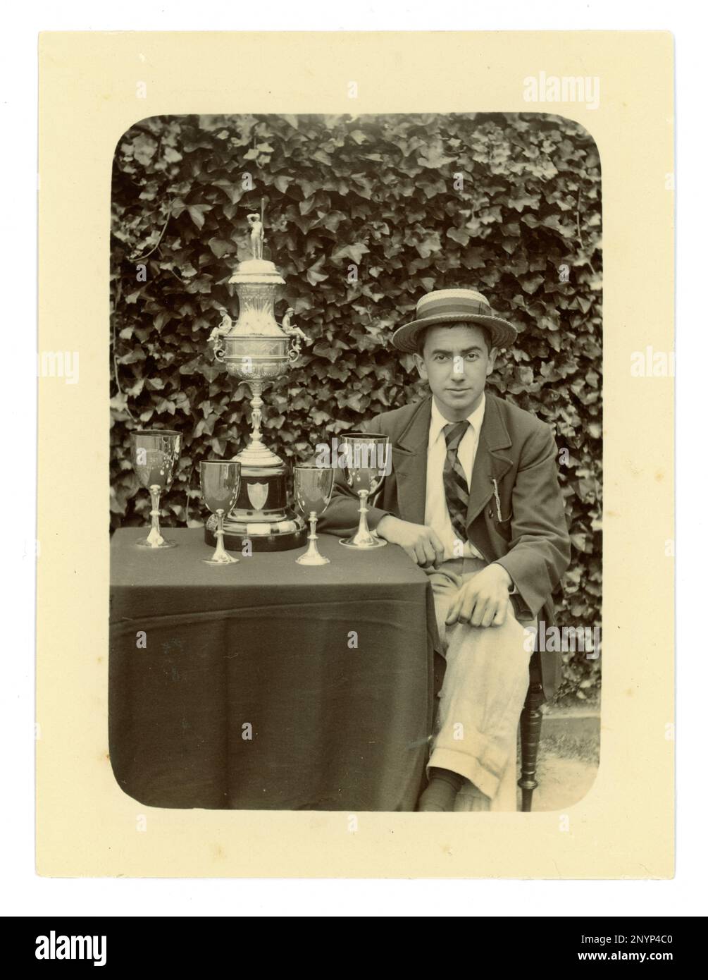 Original-viktorianisches Foto eines Gentlemen, der eine Jacke, eine Krawatte und einen Bootsfahrer trägt. Auf einem Tisch befindet sich eine große Worcester Challenge Vase,/Regatta-Trophäe zum Rudern und andere Pokale, möglicherweise Mitglied einer gefrästen vier-Mannschaft. Worcester Gegend, Großbritannien, ca. 1897-1899 Stockfoto Original-viktorianisches Foto eines Gentlemen, der eine Jacke, eine Krawatte und einen Bootsfahrer trägt. Auf einem Tisch befindet sich eine große Worcester Challenge Vase,/Regatta-Trophäe zum Rudern und andere Pokale, möglicherweise Mitglied einer gefrästen vier-Mannschaft. Worcester Gegend, Großbritannien, ca. 1897-1899 Stockfoto