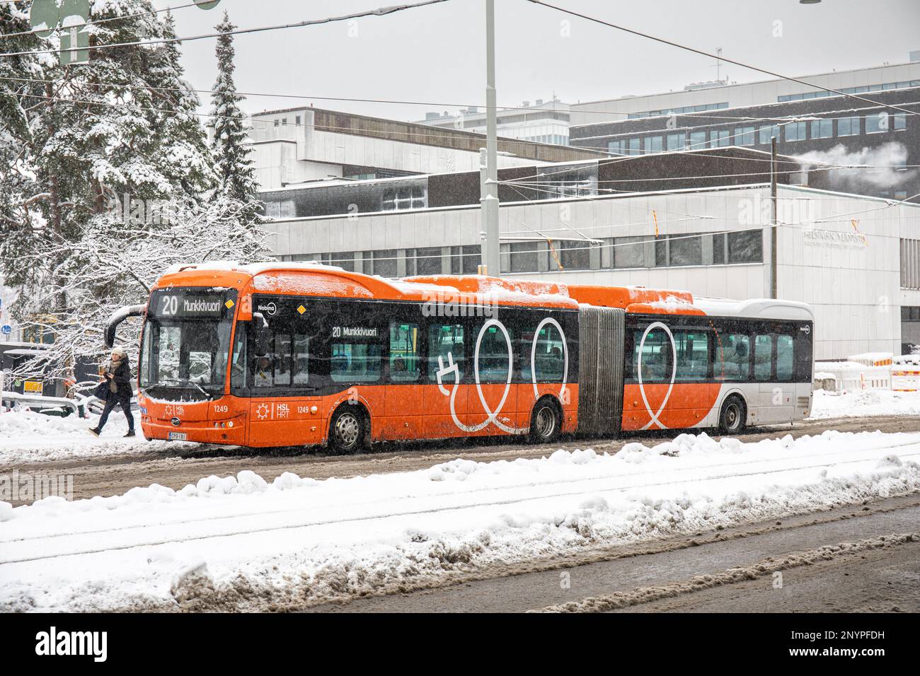 Gelenkbus der Linie 20 an der Bushaltestelle Haartmaninkatu an einem grauen Wintertag im Bezirk Meilahti in Helsinki, Finnland Stockfoto