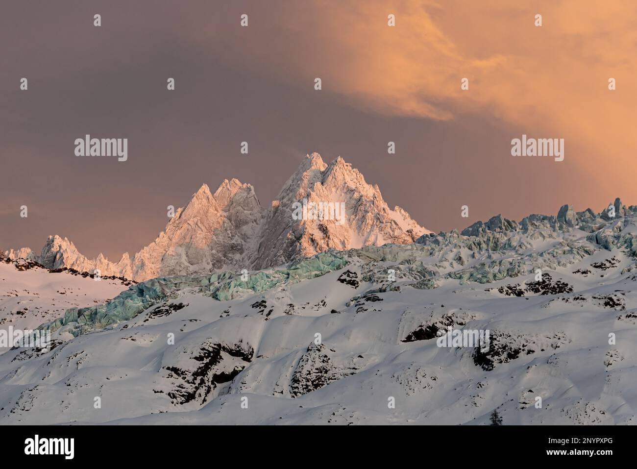 Aiguille du Tour erleuchtet durch den Winteruntergang mit den freiliegenden Seraken der Glaicier du Tour, die einen langen Hügel unter dem Berggipfel in Cham bilden Stockfoto