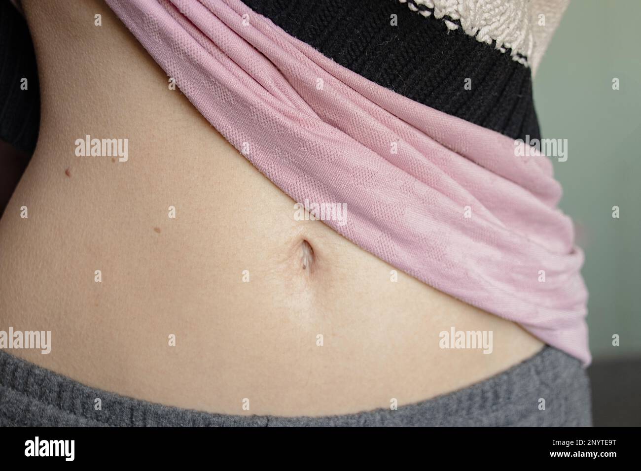 Der Bauch eines jungen Mädchens mit einer Bauchnabel-Nahaufnahme Stockfoto