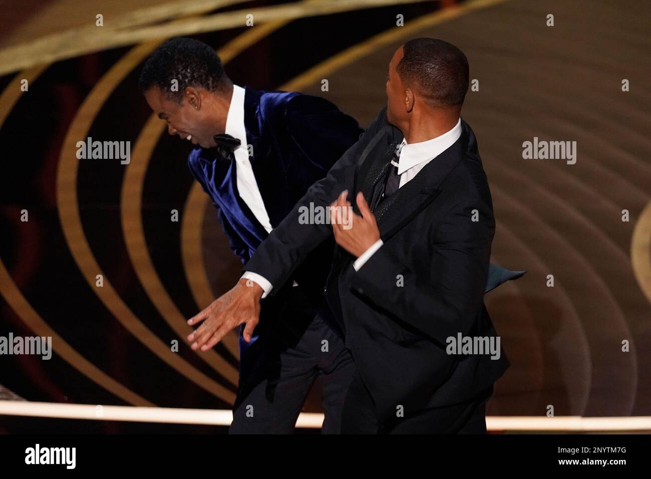 FILE - Will Smith, right, hits presenter Chris Rock on stage while presenting the award for best documentary feature at the Oscars on Sunday, March 27, 2022, at the Dolby Theatre in Los Angeles. Rock will be the first artist to perform on Netflix's first-ever live, global streaming event. (AP Photo/Chris Pizzello, File) Stockfoto