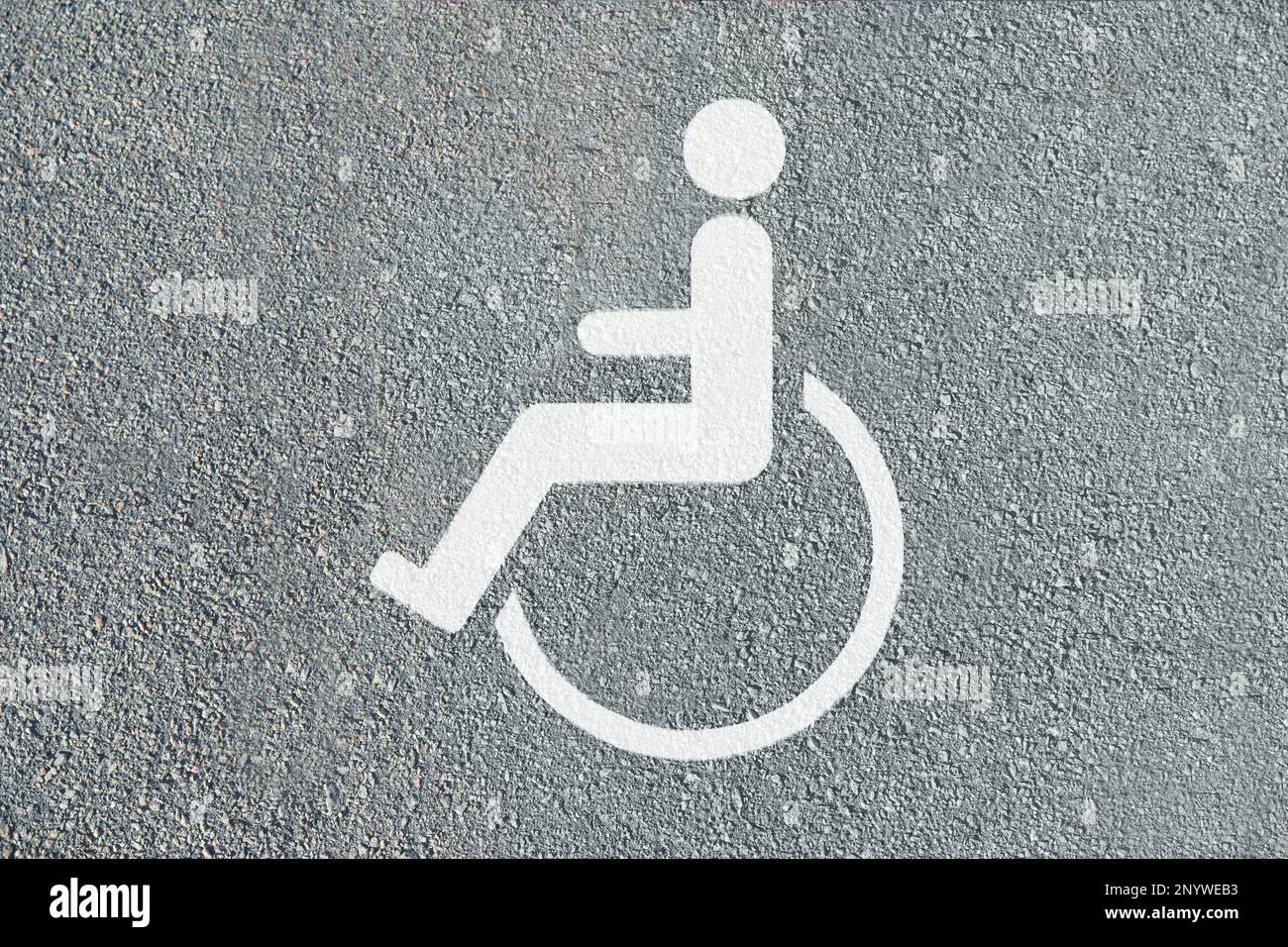 Rollstuhl-Symbol auf Asphaltstraße, Draufsicht. Behindertenparkschein Stockfoto
