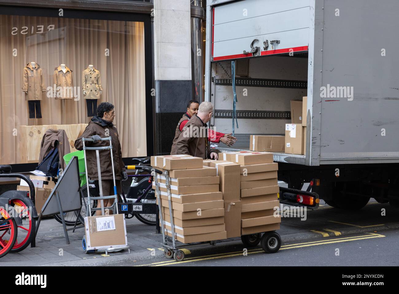 DHL, Kurier, Paketzustellung und Expressversand, Zustellung von Paketen in Mayfair, London, England, Großbritannien Stockfoto