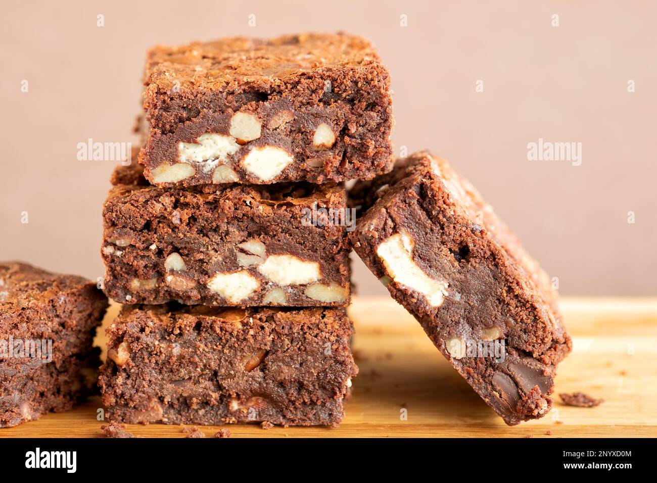 Eine Charge frisch gebackener dreifach-Schokoladen-Brownies auf einer Holzplatte. Die Brownies sind noch warm und klebrig. Ein Genuss Stockfoto
